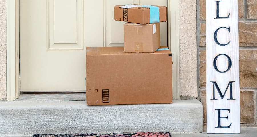 Packages on the doorstep of a home with a welcome sign in El Paso